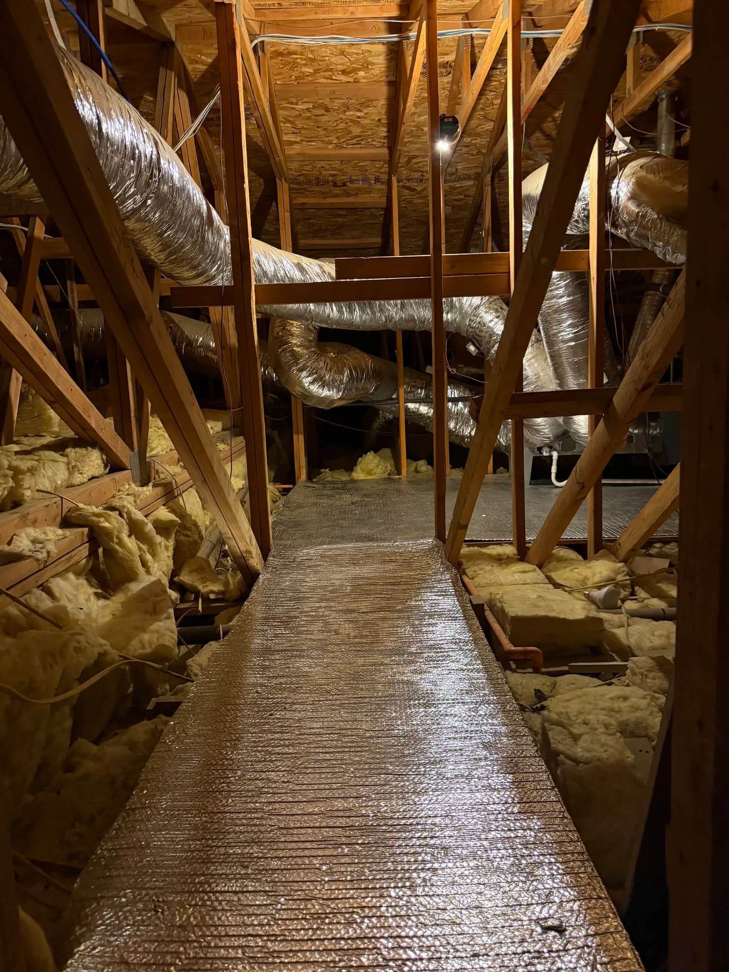 Attic walkway showcasing routed ductwork